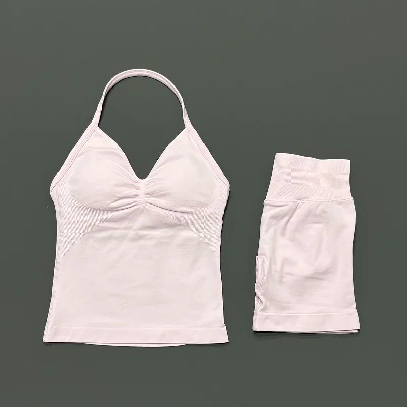 A white women's seamless backless fitness set consisting of a cropped top and matching shorts.