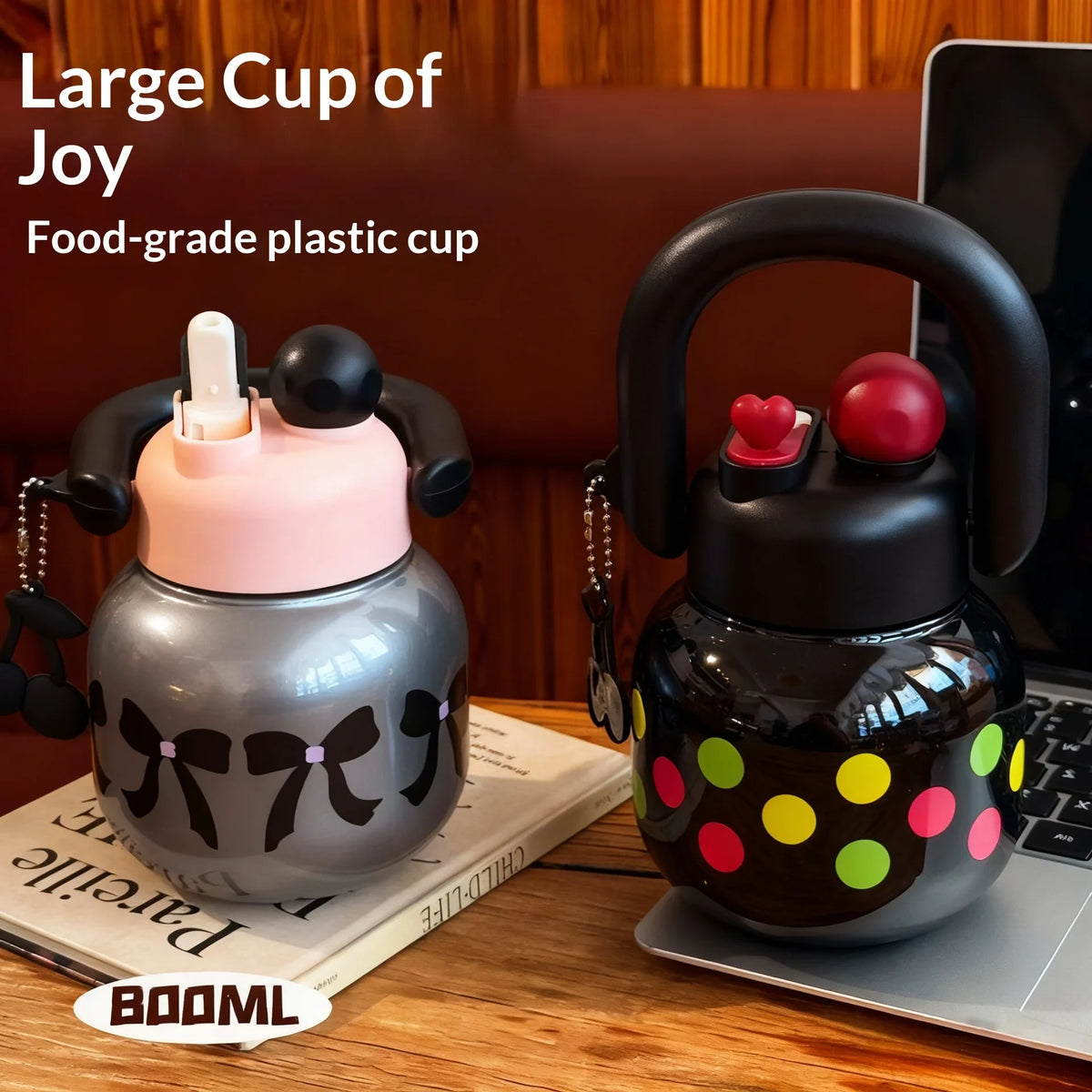 Una taza de plástico oscura diseñada para la alegría junto a una botella aislada negra con tapa roja y lunares amarillos