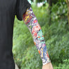 Close-up of a person wearing colorful, floral-patterned ice silk tattoo sleeves on their arm.