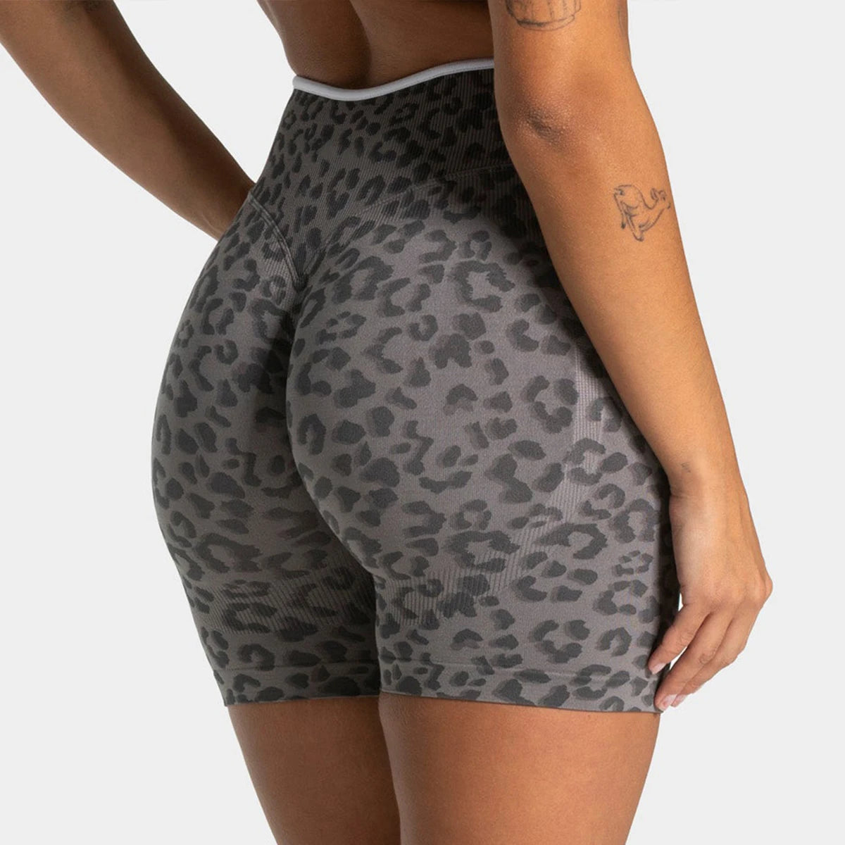 A woman wearing leopard print seamless yoga shorts in gray