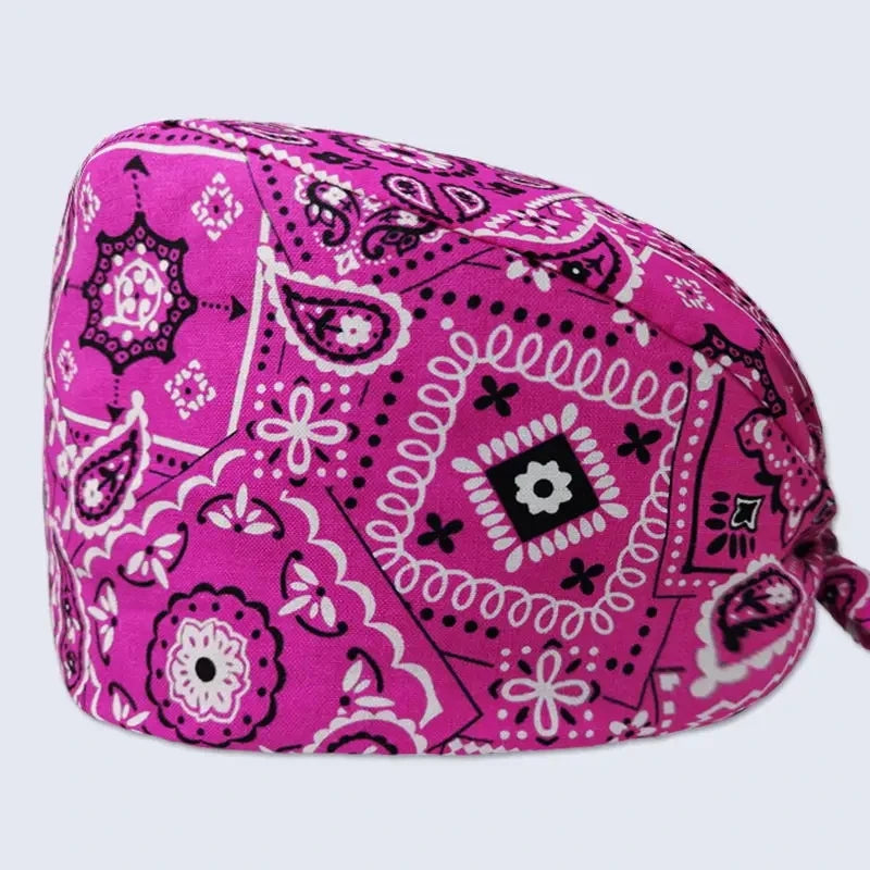 A vibrant magenta printed cotton surgical cap featuring intricate black and white floral patterns.