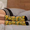 Yellow sunflower print breathable crew socks worn on a person's foot.