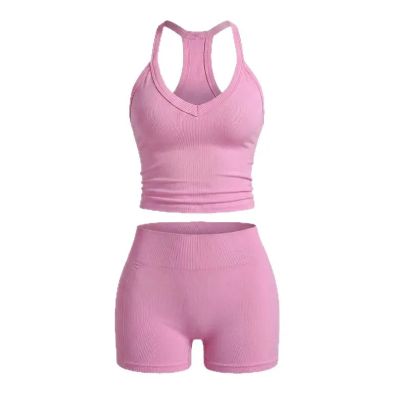 A pink two-piece women's yoga set featuring a racerback tank top and matching shorts.