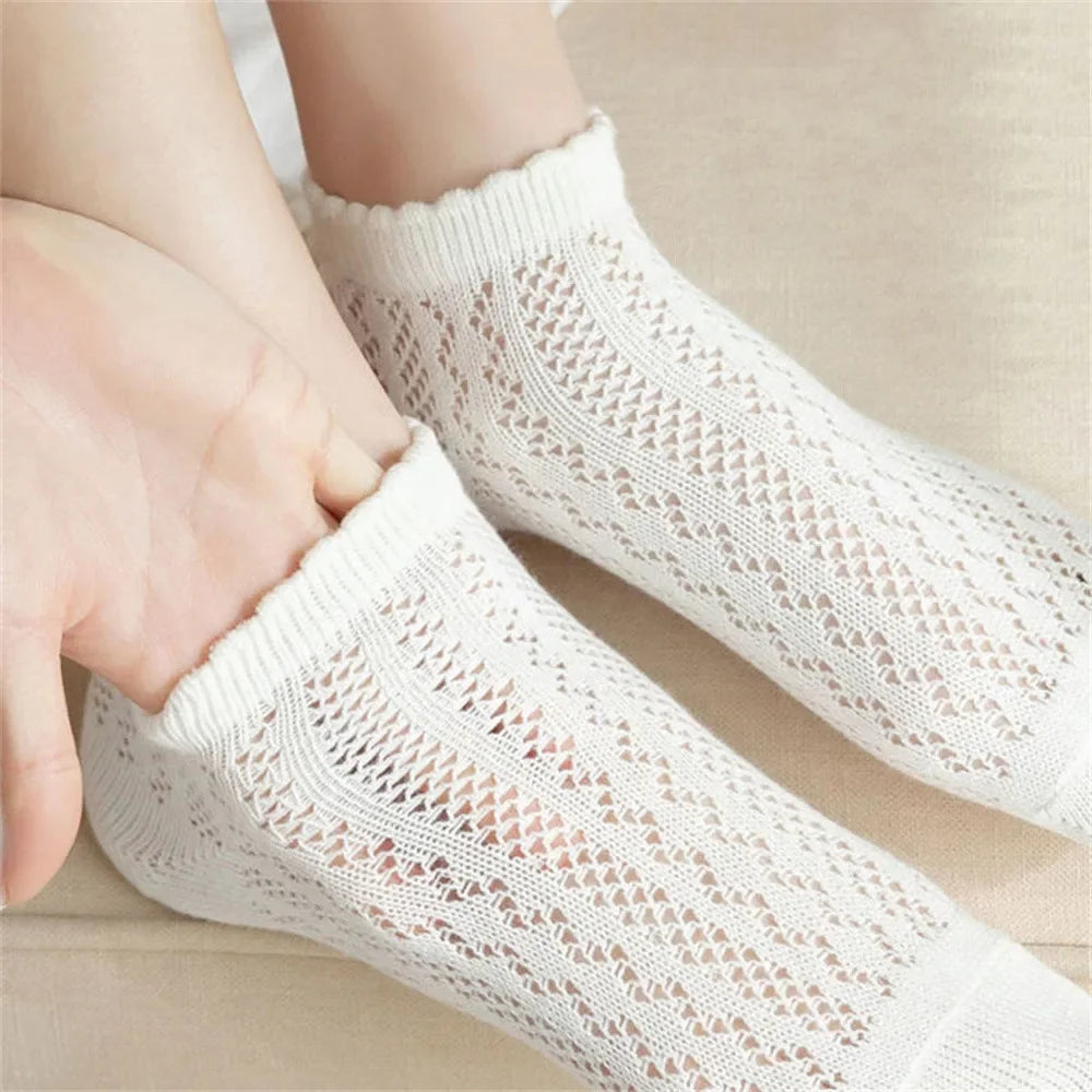 White breathable mesh lace tube socks being worn on a foot and hand.