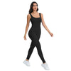 A woman models a black ribbed nylon bodycon jumpsuit with white sneakers.