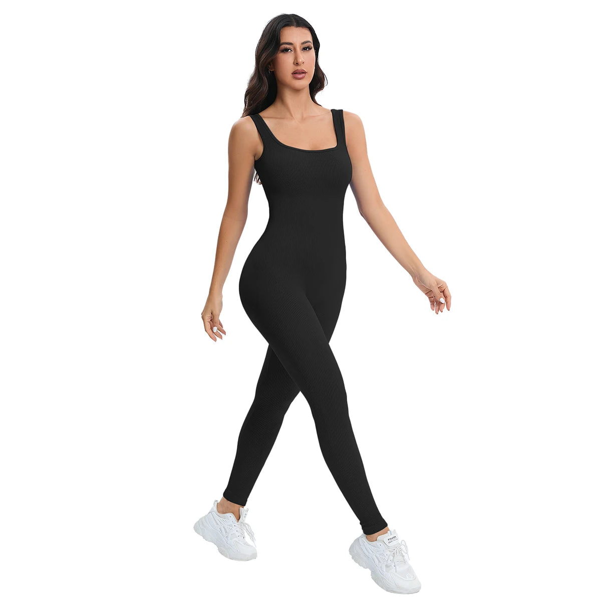 A woman models a black ribbed nylon bodycon jumpsuit with white sneakers.
