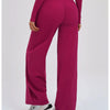 A model wearing magenta high-waist wide-leg yoga leggings and gray sneakers.