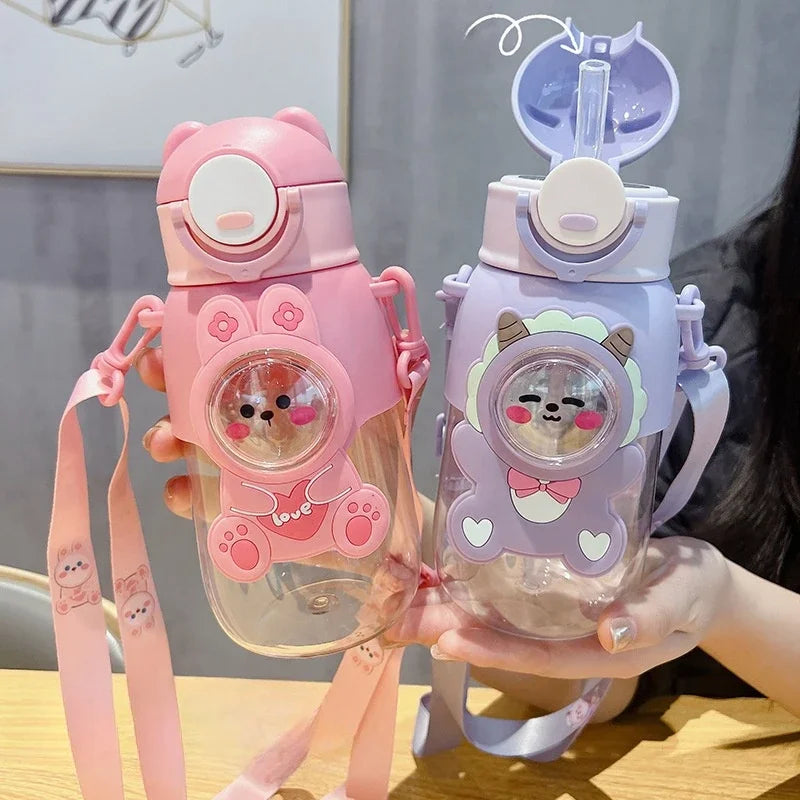 A hand holds a pink and purple leak-proof water bottle shaped like a cartoon animal.