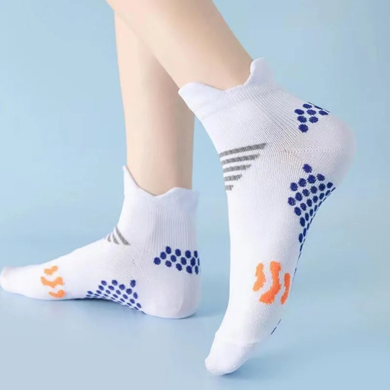 White compression running socks with blue and orange patterns worn on a leg.