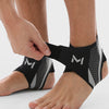 A person's foot is shown wearing black and gray compression ankle support foot sleeves.