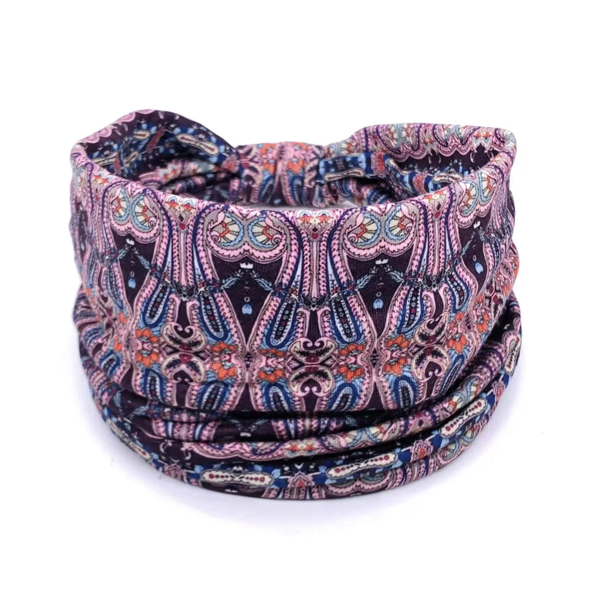 A close-up of a dark patterned bohemian stretch cotton headband rolled into a coil.