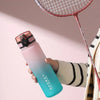 Eine Hand hält eine gradientierte isolierte Wasserflasche in rosa und blauen Tönen neben einem Tennisschläger.