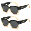 Black sunglasses with gold accents and a tortoiseshell frame shown in a studio shot.
