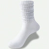 A white slouch knit sock shown from the side, highlighting the ribbed cuff and foot.