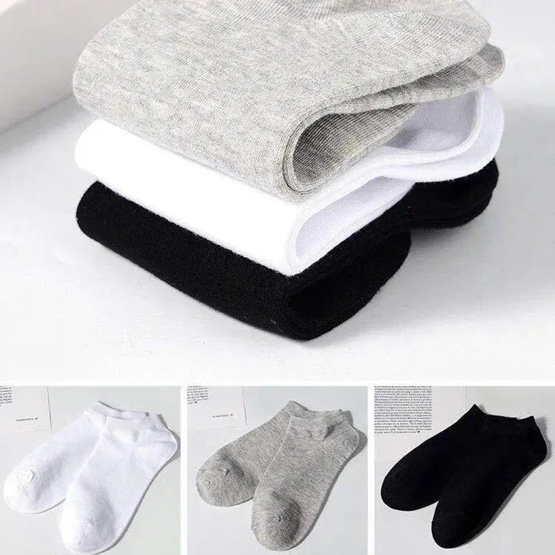 Una pila de calcetines de algodón unisex transpirables, en varios tonos como gris, blanco y negro.