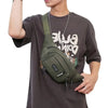 A man wearing a dark t-shirt with a green nylon waist bag slung across his chest.