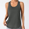 A woman wearing a dark gray running and yoga vest and light gray leggings.