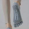 A close-up of light blue five-finger yoga socks worn on a foot, showing the patterned design.