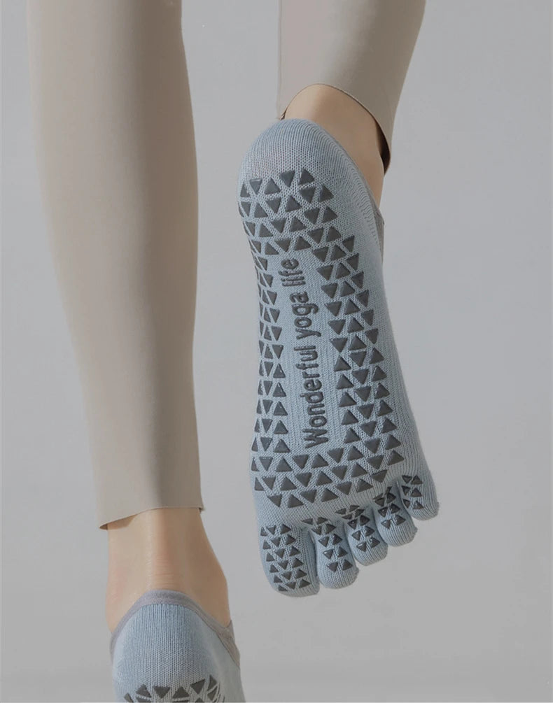 A close-up of light blue five-finger yoga socks worn on a foot, showing the patterned design.
