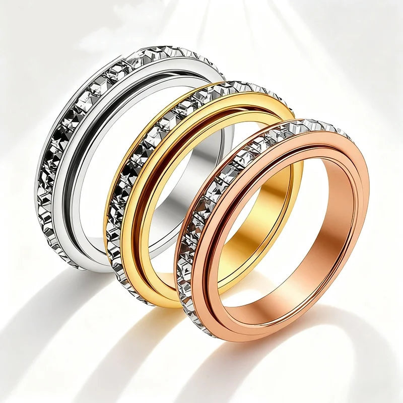 Three stacked rings of varying silver and gold tones featuring clear CZ gemstones.