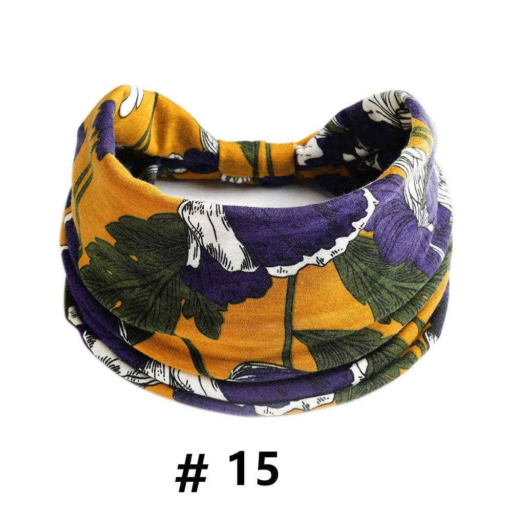 Un bandeau élastique en coton bohème coloré avec un motif floral aux tons de violet, vert et jaune moutarde.