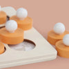 A set of wooden memory match puzzles featuring orange and white spheres and discs.