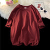 Maritimes, überdimensioniertes Baumwoll-T-Shirt für Damen auf schwarzer Fläche mit flauschigem weißen Teppich und Karte.