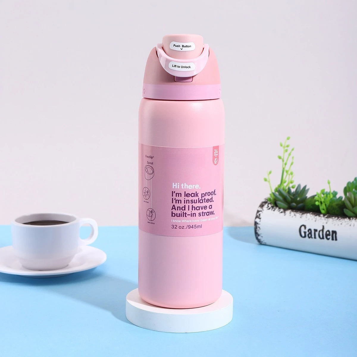 A pink stainless steel vacuum insulated water bottle with a push button lid and straw, sitting on a white coaster.