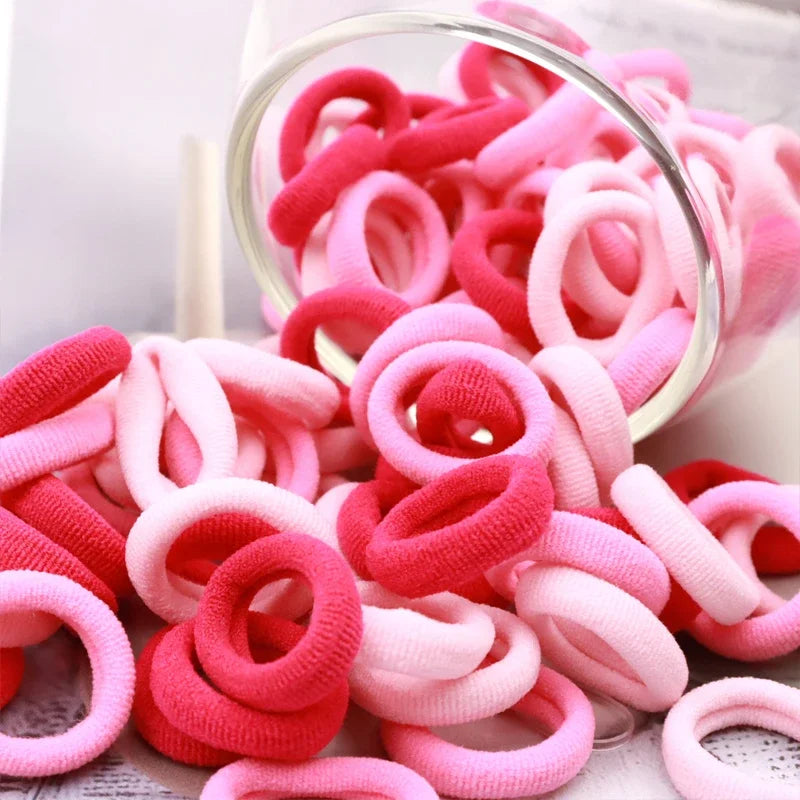 Haufen bunter rosa und roter Nylon-Haargummis für Pferdeschwänze und Zöpfe.