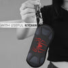 A black silicone pouch featuring a red spider web design is being held by a hand with a keychain attached.