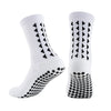 A pair of white athletic grip socks featuring black geometric patterns and a textured sole.