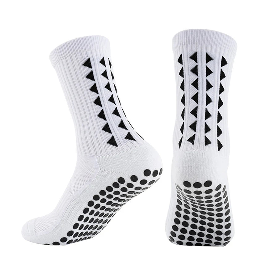 A pair of white athletic grip socks featuring black geometric patterns and a textured sole.
