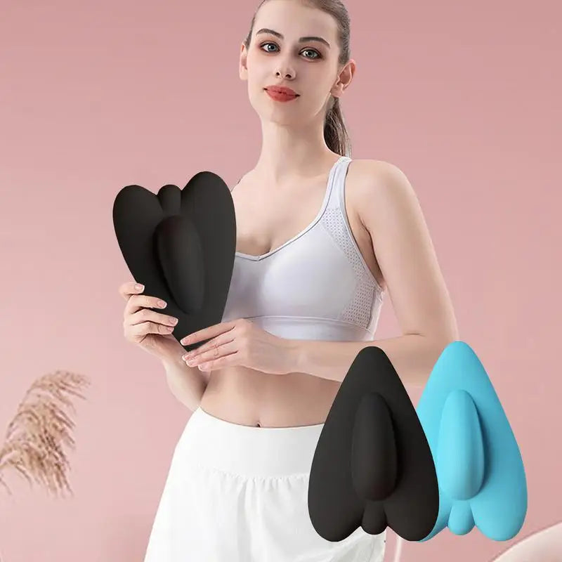 A woman holds a black pelvic floor muscle trainer device against her lower abdomen.