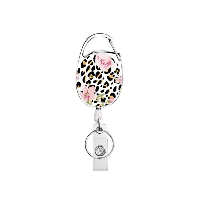 A pink and black leopard print badge reel keychain with a silver clasp.
