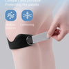 A hand is applying a black TPE patellar strap to a person's knee for shock absorption and decompression.