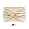 A beige boho wide turban headband folded and displayed on a white background.
