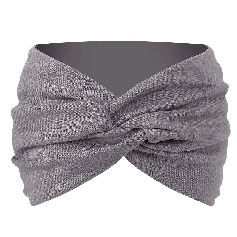 A gray twisted criss cross elastic headband is shown folded and wrapped around a head.