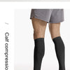Black calf compression leg sleeves worn by a person, shown in a full-length view.