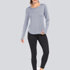 A woman models a light gray loose fit long-sleeve t-shirt and black leggings.