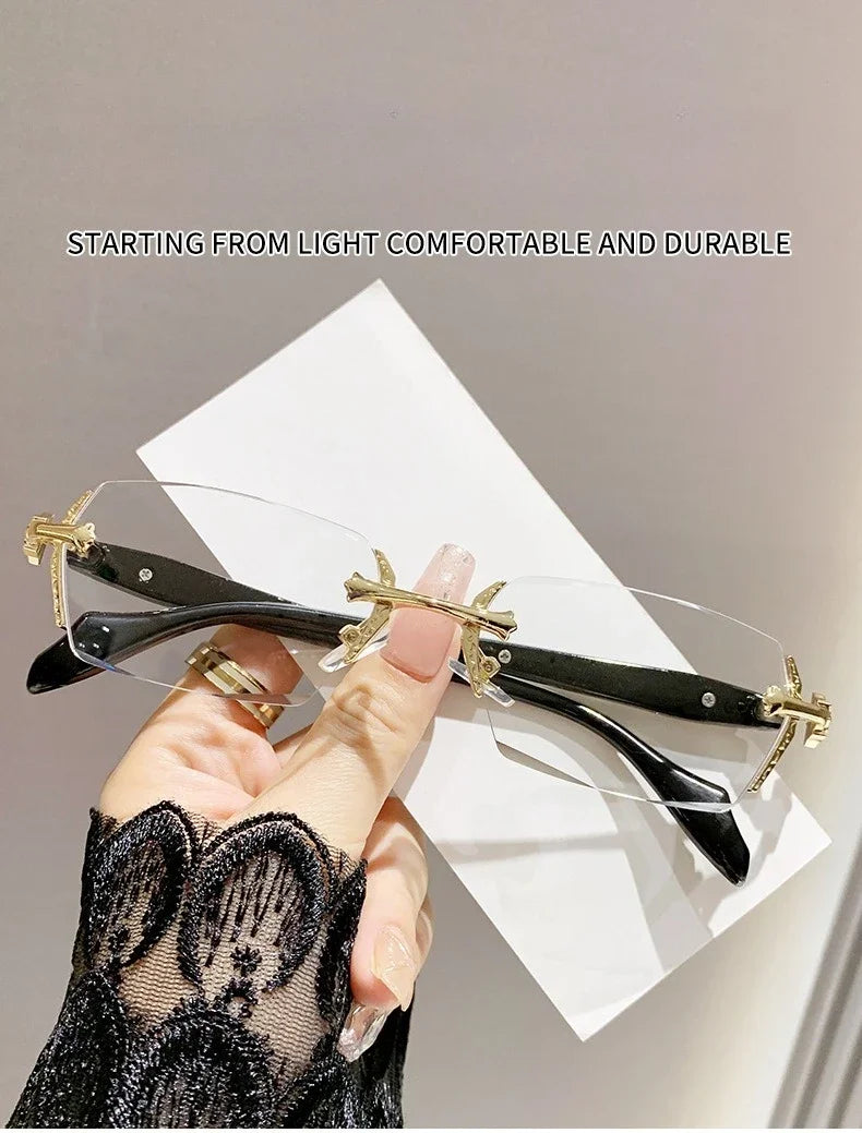 A hand holds a pair of frameless photochromic prescription glasses with gold accents against a white background.