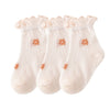 A pack of three thin, light pink baby socks with ruffled cuffs and small orange floral patterns.