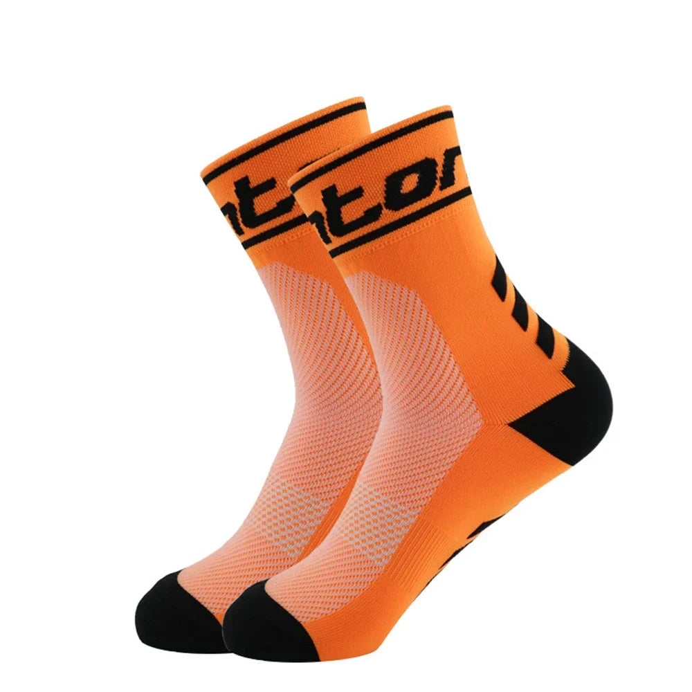 A pair of bright orange performance cycling and running socks shown from the side.