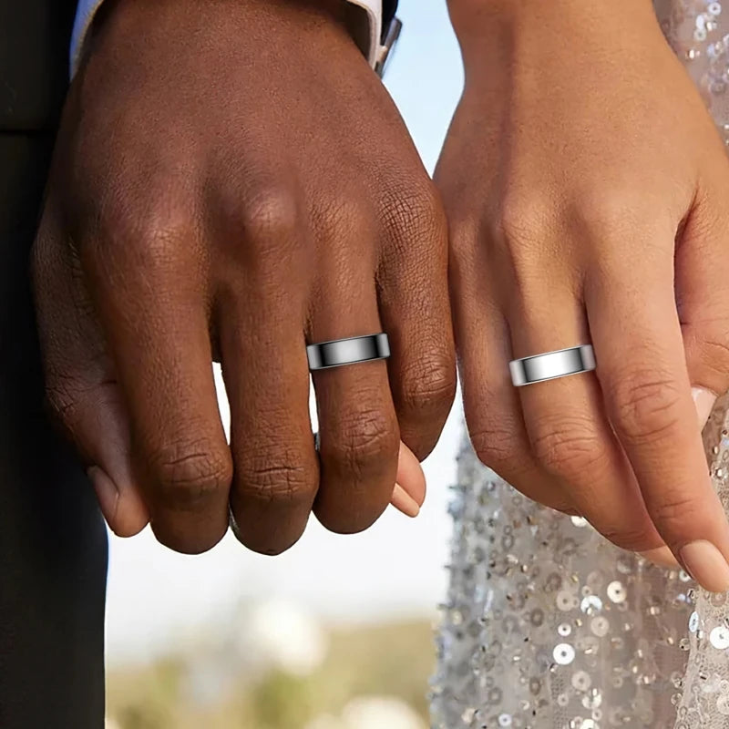 Close-up of a person's hands wearing silver smart health rings on a sparkling garment.