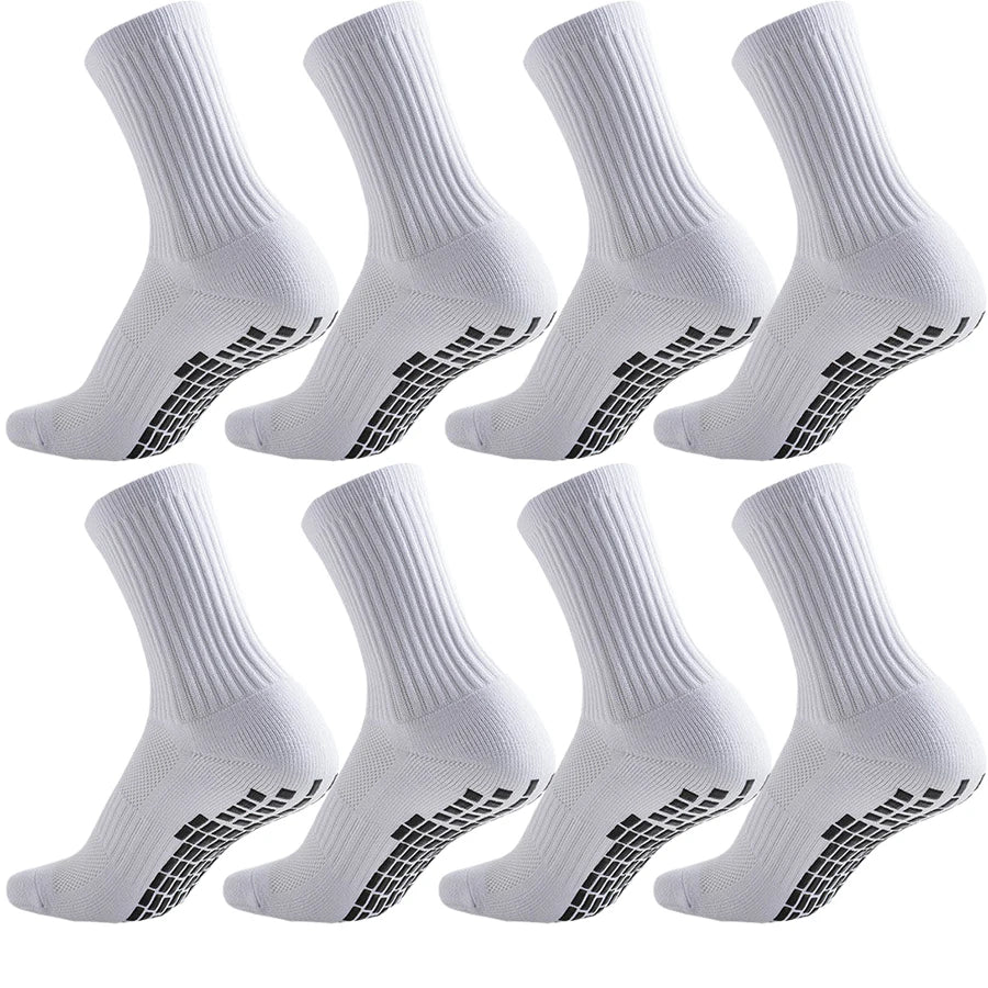 A set of white athletic grip socks shown from the side, highlighting the textured sole.