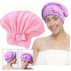 A woman models a purple hair drying towel cap, showing its texture and fit.