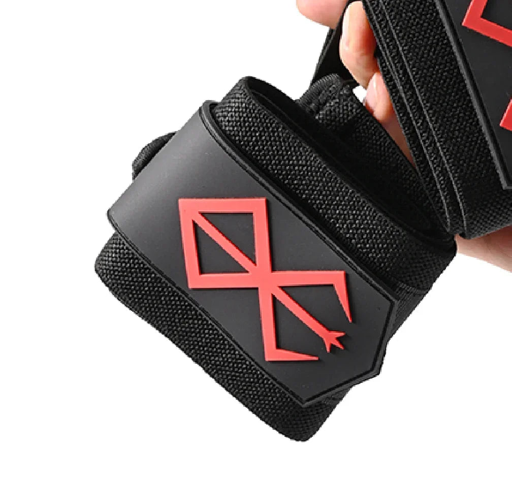 Un bracelet épais noir avec un motif rouge croisé est tenu par une main.