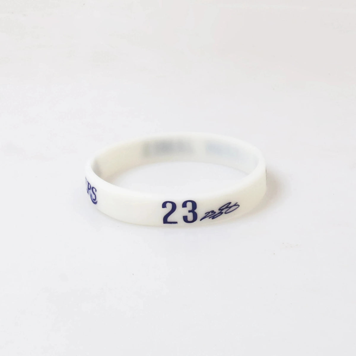 A white silicone wristband with the number 23 printed on it.