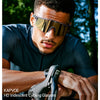 A man wearing KAPVOE HD Iridescent Cycling Glasses while cycling outdoors.