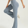 A person wearing light blue high-waisted bootcut yoga pants and a matching top, standing and posing.