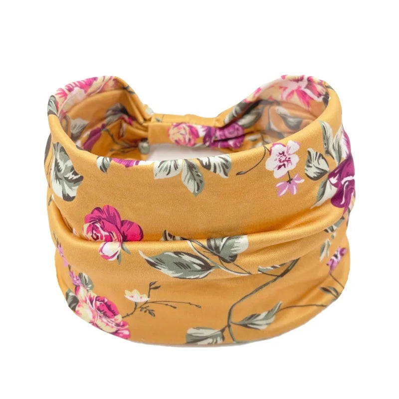 A mustard yellow floral butterfly headband with pink and green leaves.